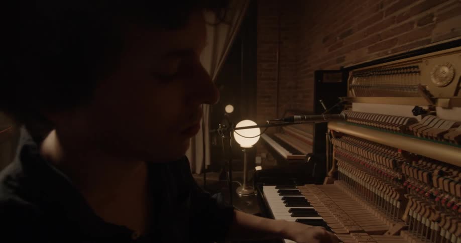 A man is playing the piano with his band