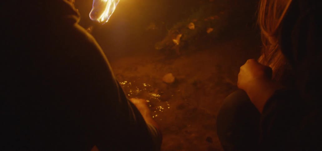 Man and woman inspecting a shallow river with a torch