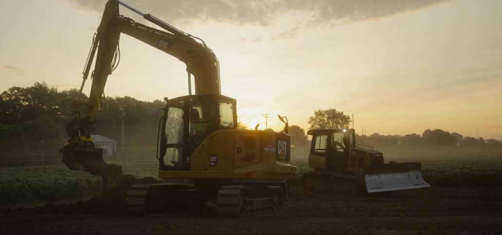 A person is operating a crane and moving dirt