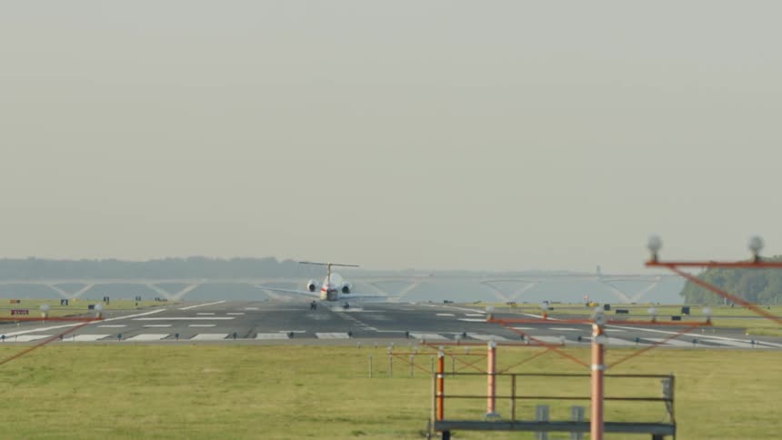 A jet lands on an airport landing strip