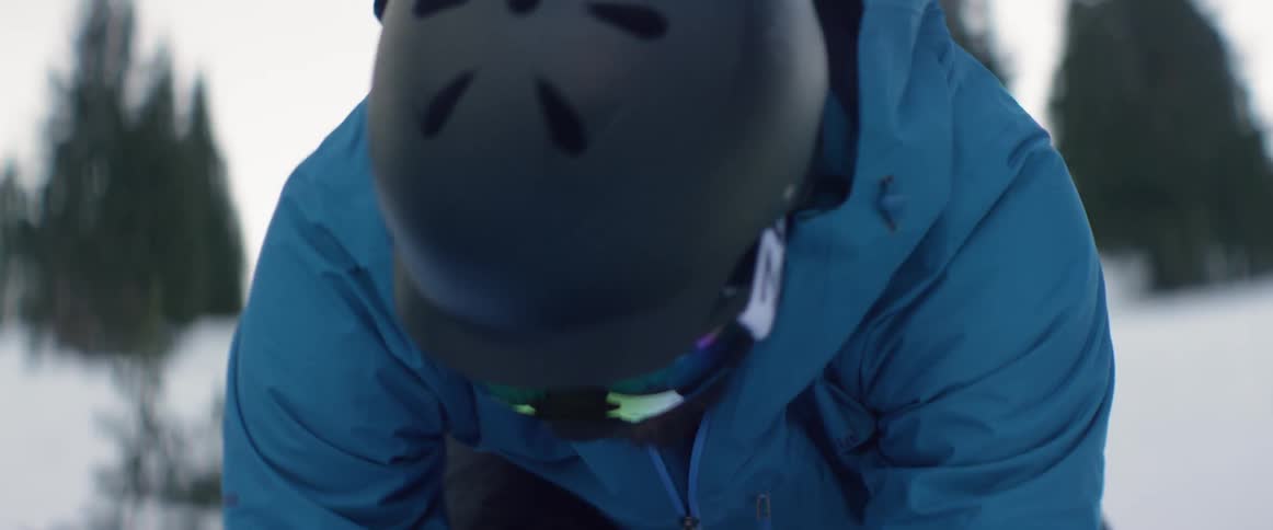A person strapping on a snowboard