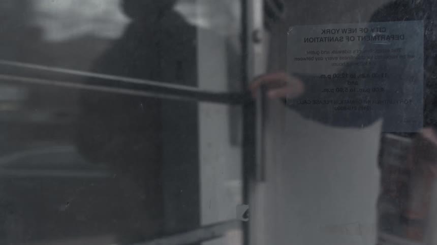 A person closing and locking a glass door