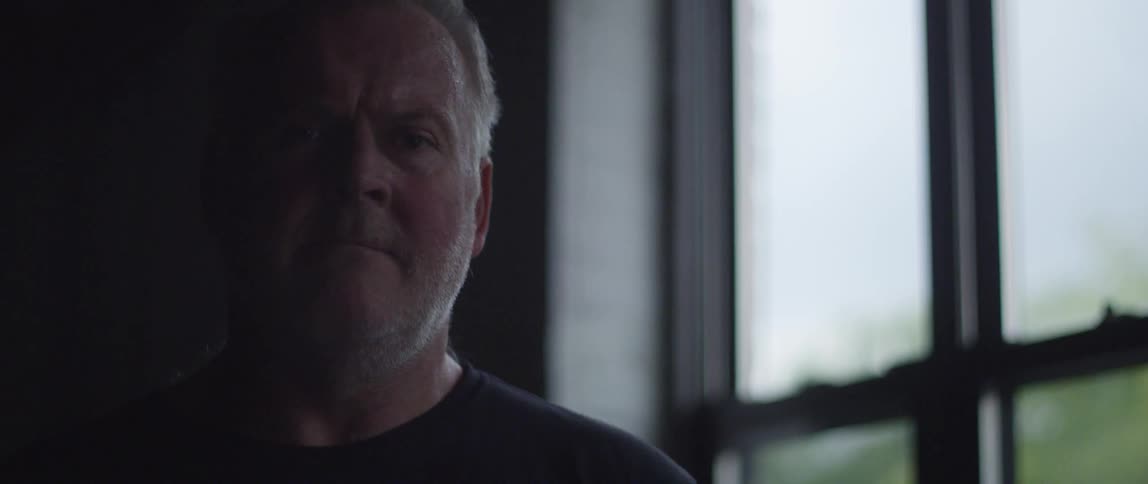 A man standing near a window