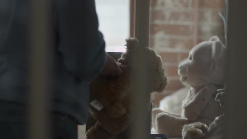 A person is playing with a teddy bear