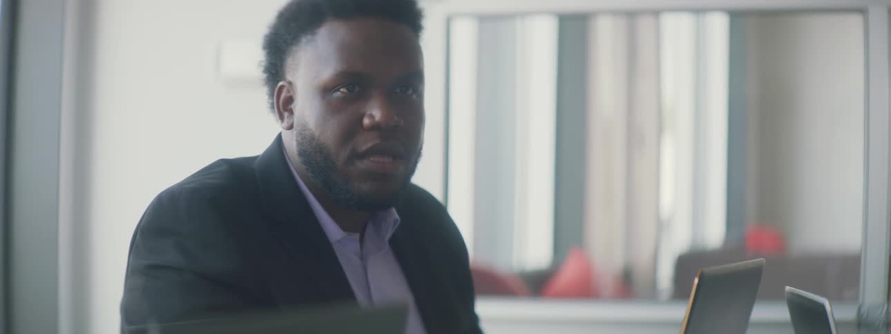 Man talks as he sits at a table in an office