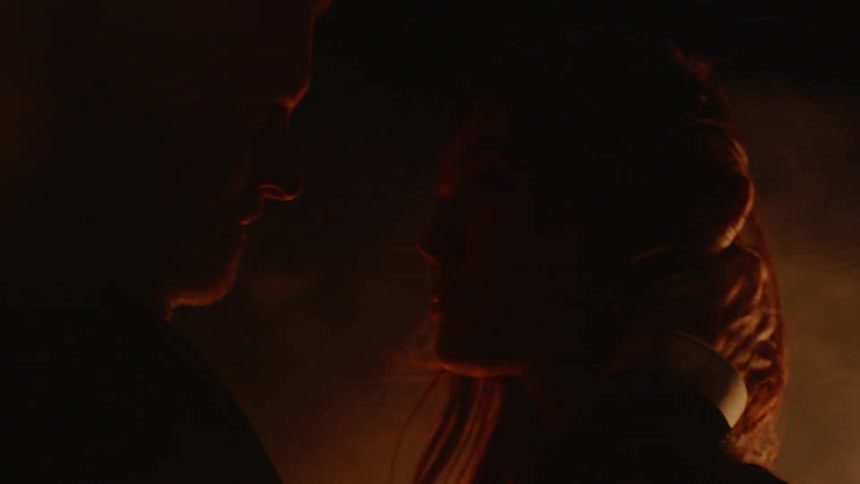 Man and woman hug outside by fire and smoke