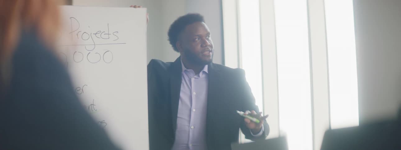 A man next to a board presenting
