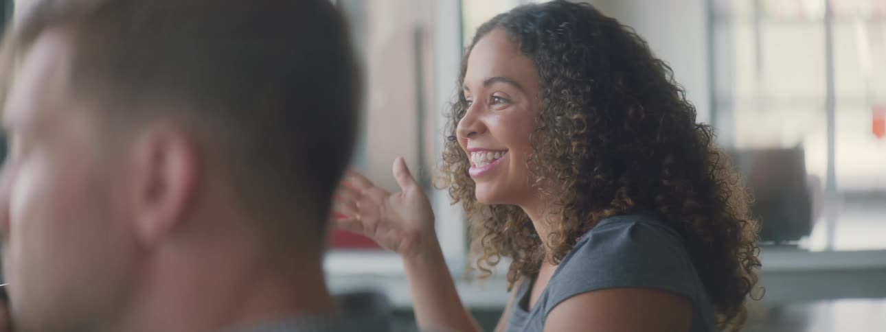 A woman talks with others while pointing