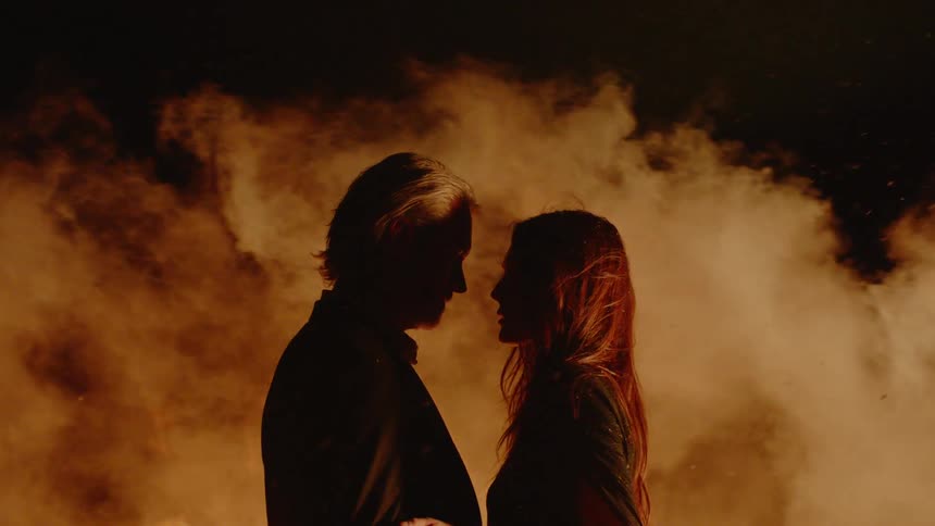 Couple Embracing While Surrounded By Fire