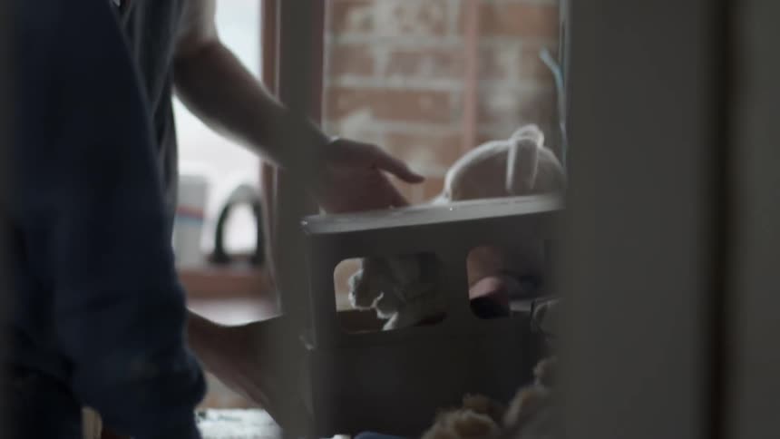 A person putting a stuffed animal in a toy car