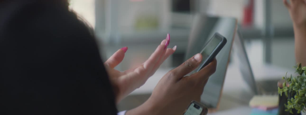 Man holds a cellphone as he talks with a woman
