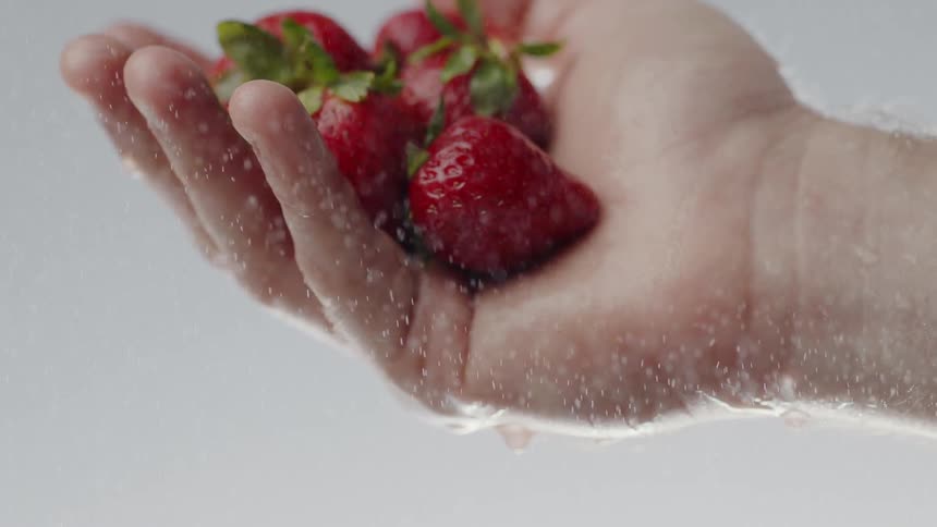 Person washing berries under water