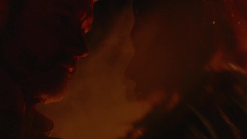 Man and woman are embracing near a bonfire at night