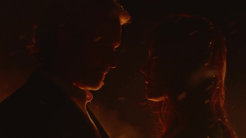 Couple Embracing While Surrounded By Fire