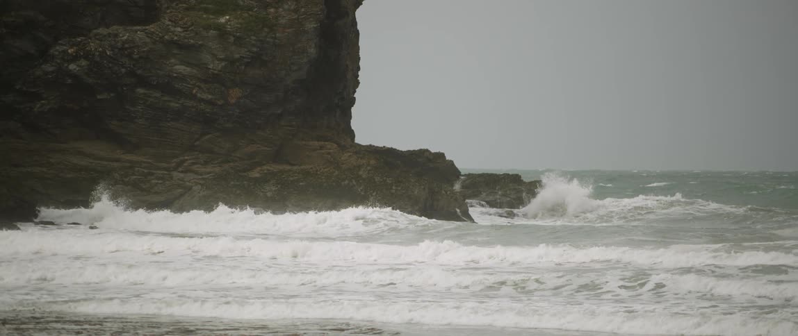 The tide flows towards the rocky shore