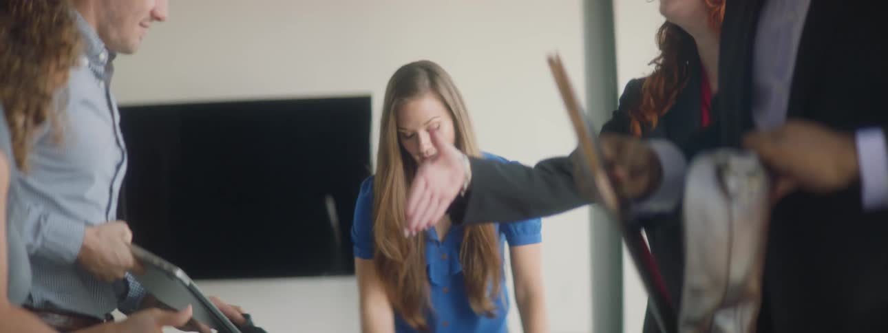 A woman standing up in an office holding a laptop