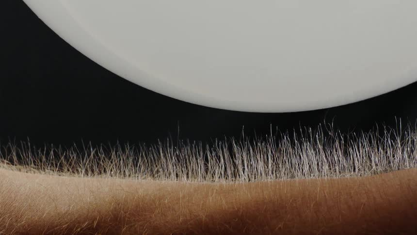 Hair on an arm is raising up and down when an object comes in contact with it