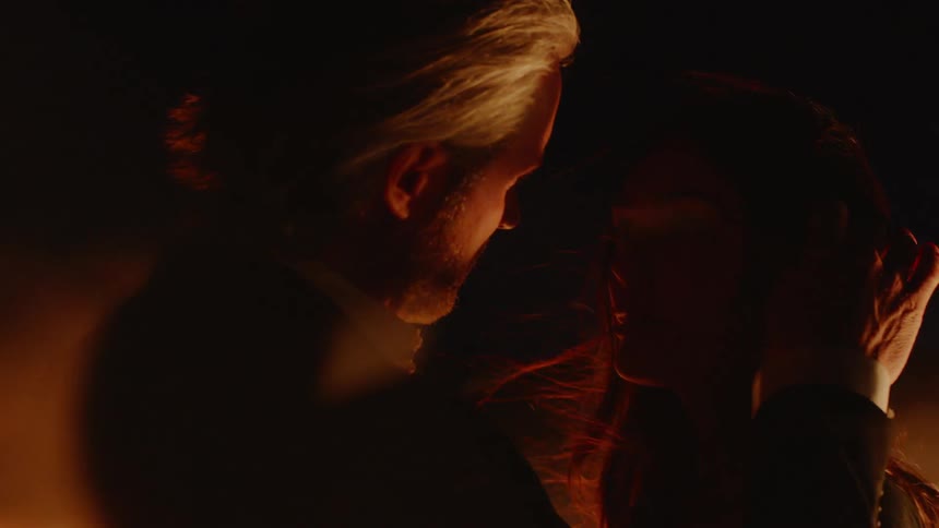 Man and woman looking at each other surrounded by smoke at night
