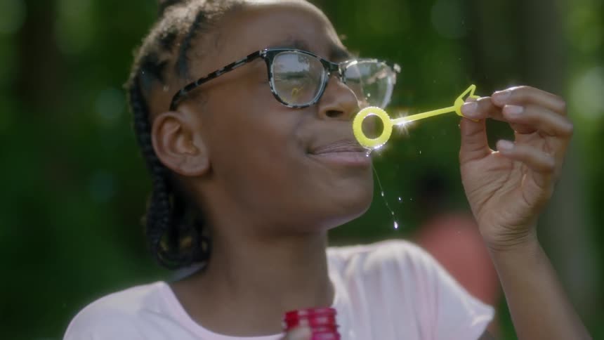 Child blows bubbles and gets liquid on her face