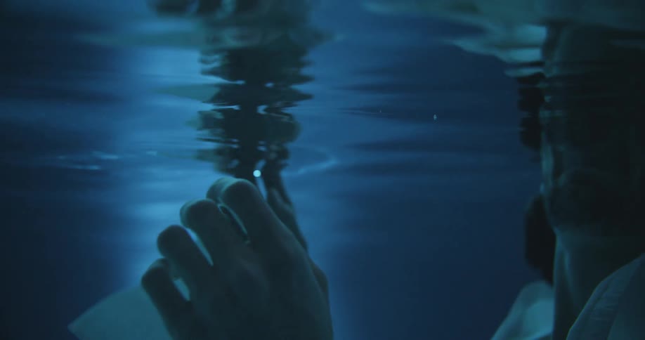 A clothed man is submerged underwater