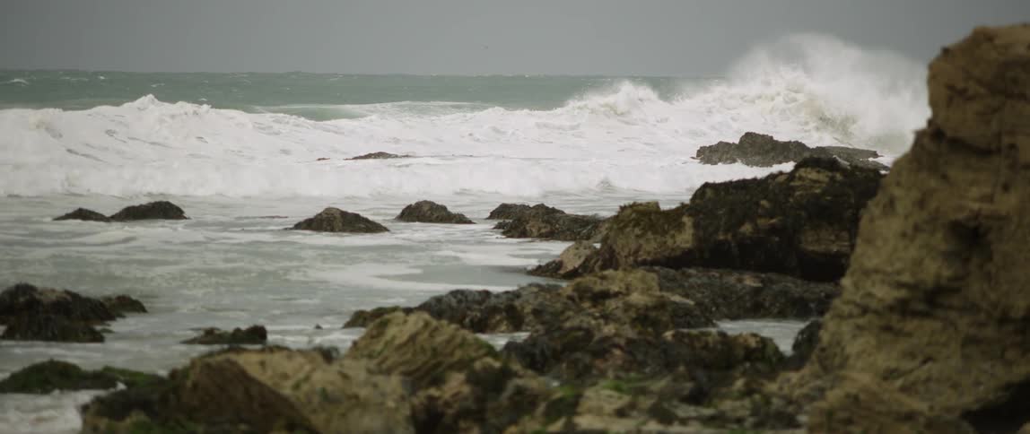 Waves crash into rocks on beach
