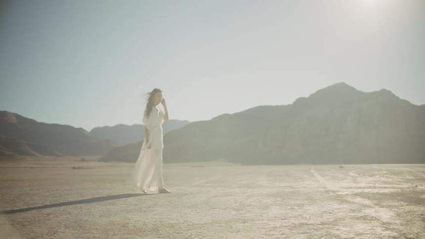 Woman stands outside in the desert on a sunny day