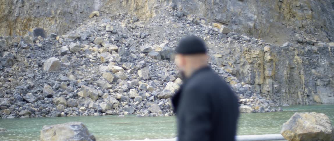 A man standing next to a flowing river