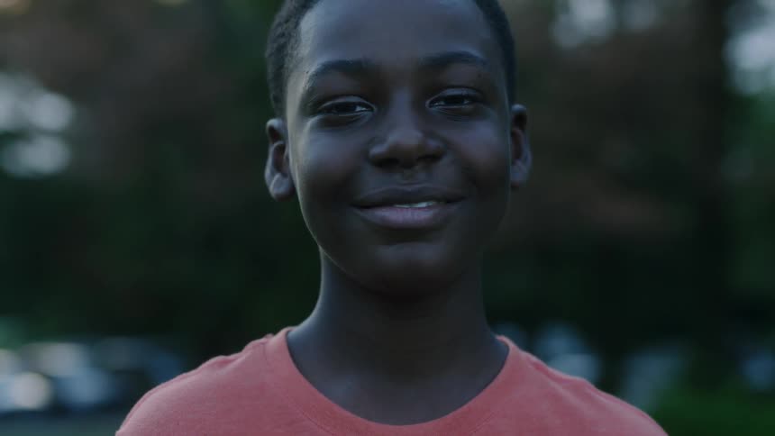 A child smiling on a dim day