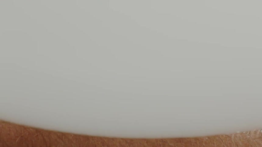 A man rubbing a balloon on his arm hair