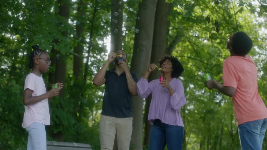 A family blow bubbles in the park
