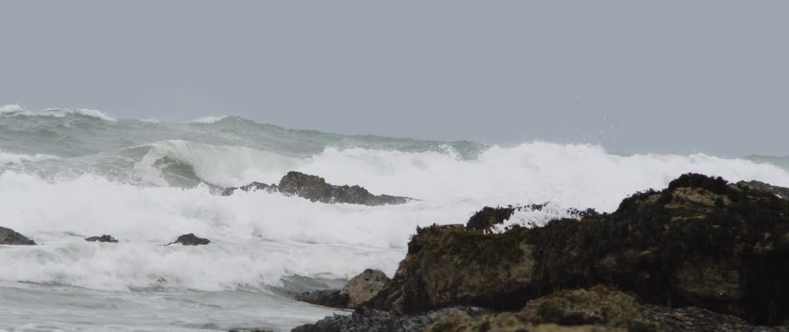 Ocean waves crash into a rocky shore
