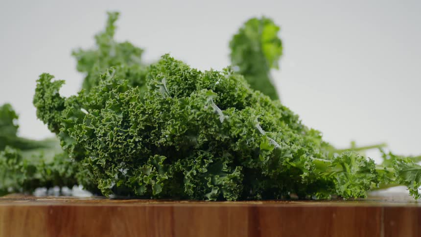 Kale leaves drop onto cutting board