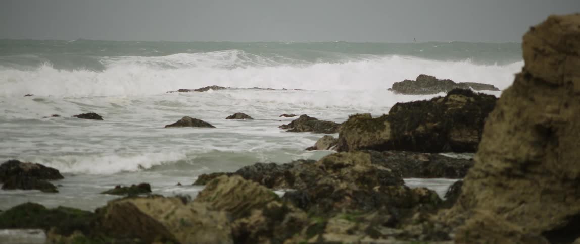 Waves are crashing by the rocks
