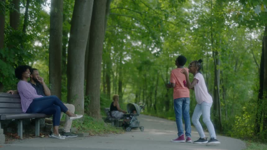 Two children blow bubbles in a park