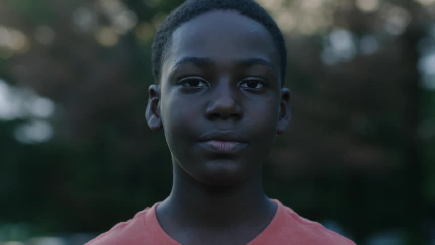A boy outside staring around at daytime