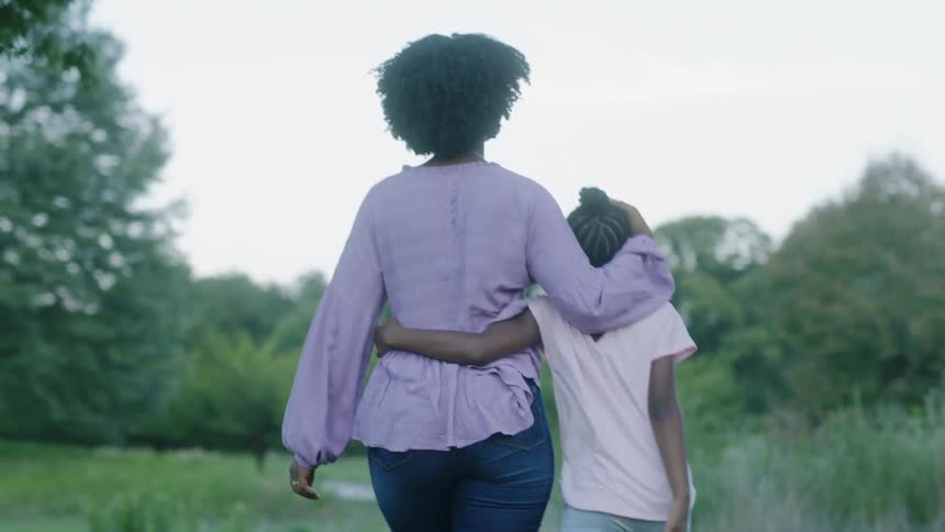 Woman and daughter and hugging and walking outside