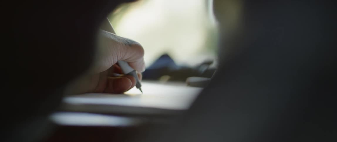A man writing on a notebook