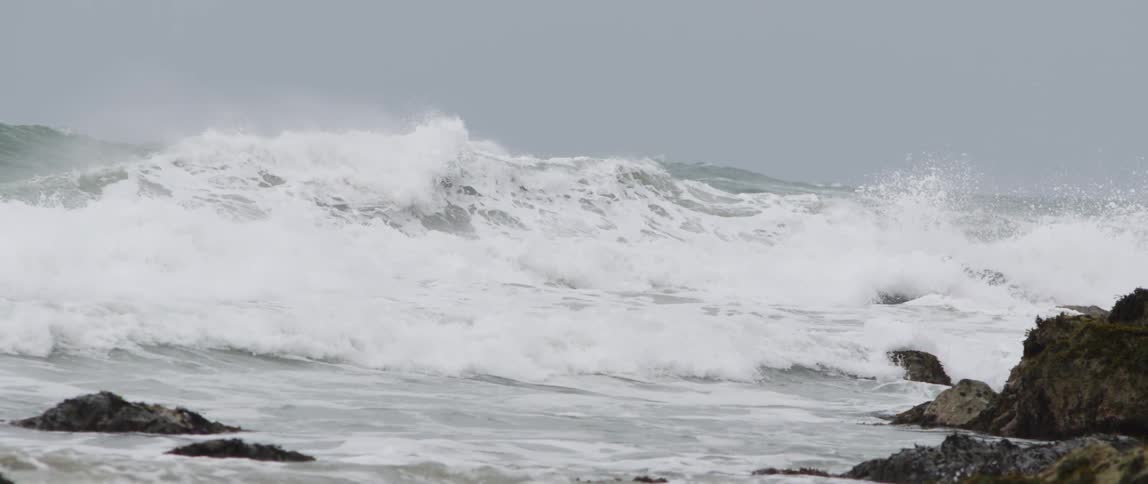 Waves are crashing by the rocks