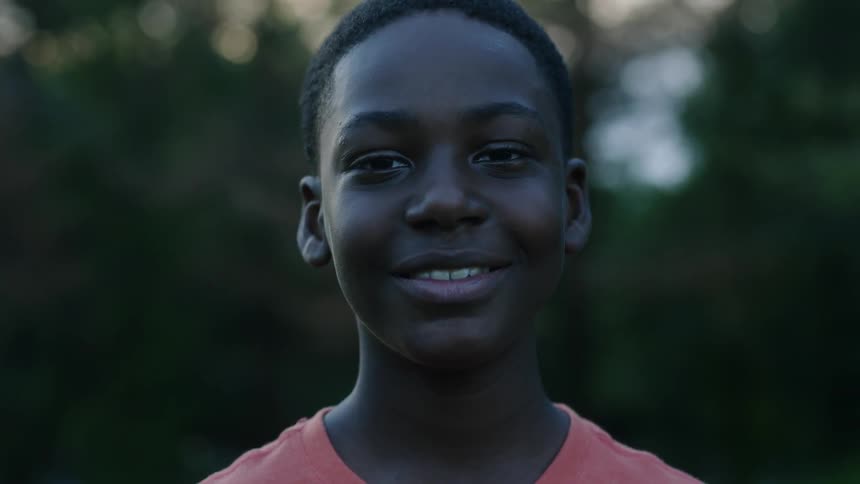 Child is smiling outside during midday