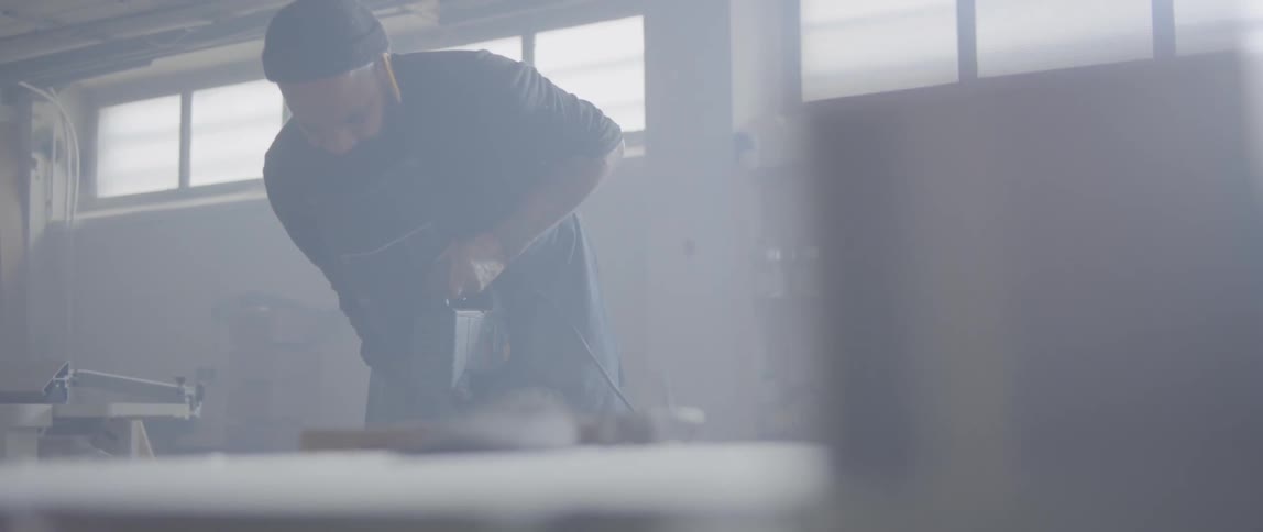 Man uses power drill in workshop