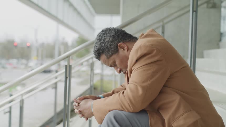 A man sitting on steps outside