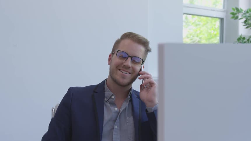 A man is talking on the phone while sitting down