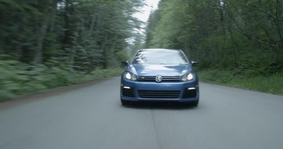 A car driving down a road in a forest