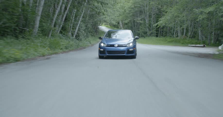 A car driving on a road in the forest