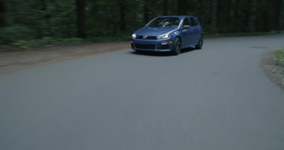 A car drives around the forest road