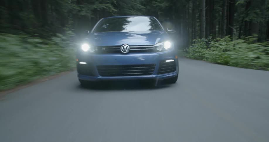 A car driving down a road in a forest