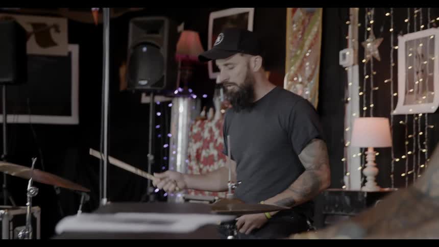 A person playing the drums next to a person playing the keyboard