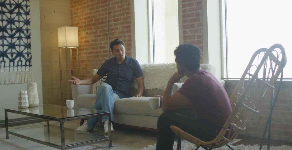 Two men sitting in a contemporary living room and chatting