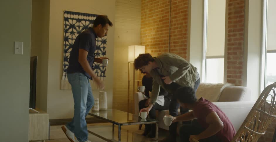 Group of people gather together around a coffee table and take seats
