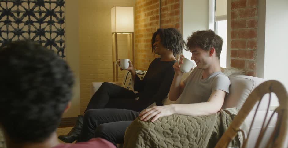 People sitting on couches talking and drinking